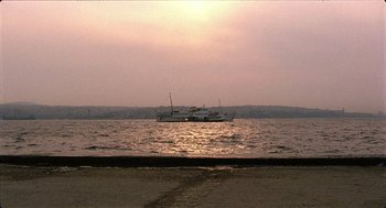 Movie still from “Distant” (2002), directed by Nuri Bilge Ceylan – A large boat in a body of water at sunset; Extreme Wide shot, Low angle