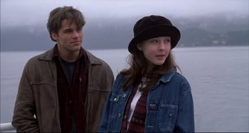 Movie still from “Disturbing Behavior” (1998), directed by David Nutter – A man and a woman standing next to each other near a body of water; Medium shot, Low angle