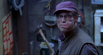Movie still from “Disturbing Behavior” (1998), directed by David Nutter – A man holding a baseball bat while wearing glasses and a purple hat; Close Up shot, Over the shoulder angle