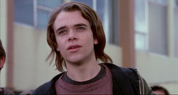 Movie still from “Disturbing Behavior” (1998), directed by David Nutter – A man with long brown hair wearing a leather jacket; Close Up shot, Low angle