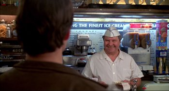 Movie still from “Disturbing Behavior” (1998), directed by David Nutter – A man wearing a white hat is smiling at another man in front of an ice cream machine; Medium shot, Over the shoulder angle