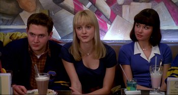 Movie still from “Disturbing Behavior” (1998), directed by David Nutter – A woman sitting between two men at a table; Medium shot, High angle