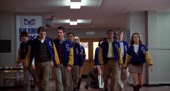 Movie still from “Disturbing Behavior” (1998), directed by David Nutter – A group of young men standing next to each other in a hallway; Wide shot, Low angle