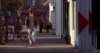 Movie still from “Disturbing Behavior” (1998), directed by David Nutter – A man standing on the sidewalk in front of a building; Wide shot, Low angle