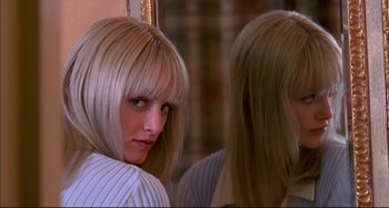 Movie still from “Disturbing Behavior” (1998), directed by David Nutter – A woman with blonde hair looking into a mirror; Close Up shot, Over the shoulder angle