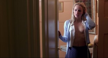 Movie still from “Disturbing Behavior” (1998), directed by David Nutter – A young woman in a blue and white shirt is standing in front of a mirror; Medium shot, Over the shoulder angle