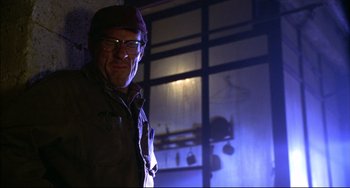 Movie still from “Disturbing Behavior” (1998), directed by David Nutter – A man wearing glasses standing in a dark room; Close Up shot, Low angle