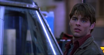 Movie still from “Disturbing Behavior” (1998), directed by David Nutter – A young man looking at the camera in front of an airplane; Close Up shot, Over the shoulder angle