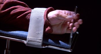 Movie still from “Disturbing Behavior” (1998), directed by David Nutter – A person holding a pair of scissors in their hand; Extreme Close Up shot, Overhead angle