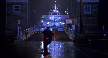 Movie still from “Disturbing Behavior” (1998), directed by David Nutter – A man riding a motorcycle down a street at night; Extreme Wide shot, Low angle