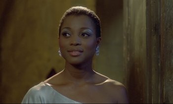 Movie still from “Diva” (1981), directed by Jean-Jacques Beineix – A woman in a white dress and a pair of diamond earrings; Close Up shot, Over the shoulder angle