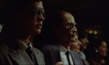 Movie still from “Diva” (1981), directed by Jean-Jacques Beineix – A group of men in suits and ties wearing sunglasses; Close Up shot, Low angle