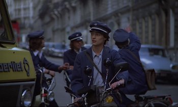 Movie still from “Diva” (1981), directed by Jean-Jacques Beineix – A group of men riding bikes down a street; Medium shot, Low angle