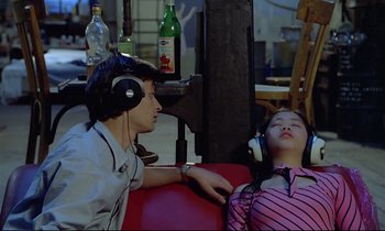Movie still from “Diva” (1981), directed by Jean-Jacques Beineix – A man and a woman listening to music on headphones; Medium shot, High angle