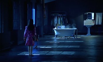 Movie still from “Diva” (1981), directed by Jean-Jacques Beineix – A woman in a pink dress walking in front of a bath tub; Wide shot, High angle