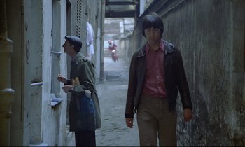 Movie still from “Diva” (1981), directed by Jean-Jacques Beineix – Two young men walking down a street in a city; Medium shot, Over the shoulder angle