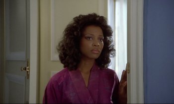 Movie still from “Diva” (1981), directed by Jean-Jacques Beineix – A woman in a purple robe standing in front of a window; Close Up shot, Over the shoulder angle