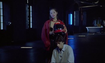 Movie still from “Diva” (1981), directed by Jean-Jacques Beineix – A man and a woman in a dark room with a helmet on; Medium shot, Low angle