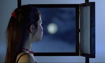 Movie still from “Diva” (1981), directed by Jean-Jacques Beineix – A woman standing in front of an open window looking out at the moon; Close Up shot, Over the shoulder angle
