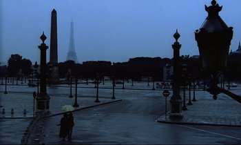 Movie still from “Diva” (1981), directed by Jean-Jacques Beineix – Two people under an umbrella in the middle of a street; Extreme Wide shot, High angle