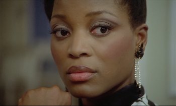Movie still from “Diva” (1981), directed by Jean-Jacques Beineix – A person wearing a black and white shirt; Close Up shot, Over the shoulder angle