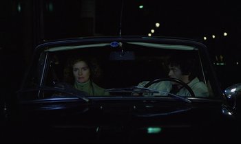 Movie still from “Diva” (1981), directed by Jean-Jacques Beineix – A man and a woman sitting in the back seat of a car; Medium shot, High angle