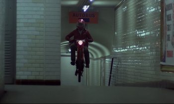 Movie still from “Diva” (1981), directed by Jean-Jacques Beineix – A man riding a bike down the side of a building; Wide shot, Low angle