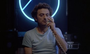 Movie still from “Diva” (1981), directed by Jean-Jacques Beineix – A man is talking on a phone while sitting in a room; Close Up shot, Low angle