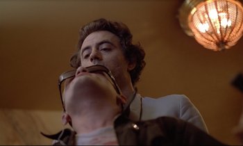 Movie still from “Diva” (1981), directed by Jean-Jacques Beineix – A man with a beard is holding his mouth open while wearing glasses; Close Up shot, Low angle