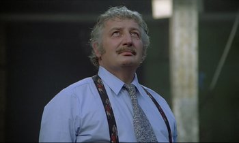 Movie still from “Diva” (1981), directed by Jean-Jacques Beineix – An older man wearing a blue shirt and a tie; Close Up shot, Low angle