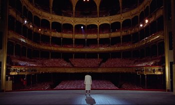 Movie still from “Diva” (1981), directed by Jean-Jacques Beineix – A man standing in front of an empty stage; Extreme Wide shot, High angle