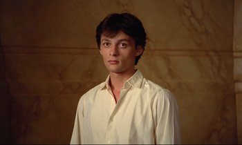 Movie still from “Diva” (1981), directed by Jean-Jacques Beineix – A man in a white shirt is standing in front of a wall; Close Up shot, Low angle