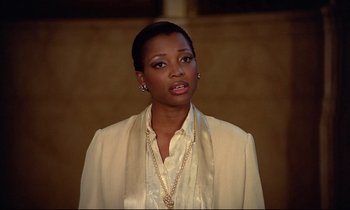Movie still from “Diva” (1981), directed by Jean-Jacques Beineix – A woman in a white jacket and a gold necklace; Close Up shot, Over the shoulder angle