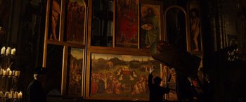 Movie still from “The Monuments Men” (2014), directed by George Clooney – A person standing in front of a wall with paintings on it; Extreme Wide shot, Low angle