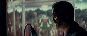 Movie still from “The Monuments Men” (2014), directed by George Clooney – A man with a beard and glasses looking at a painting on the wall; Close Up shot, Low angle