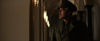 Movie still from “The Monuments Men” (2014), directed by George Clooney – A man in a uniform is standing in a hallway; Medium shot, Low angle