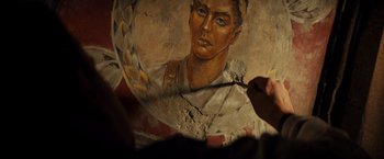 Movie still from “The Monuments Men” (2014), directed by George Clooney – A person is holding a knife and a painting; Close Up shot, Over the shoulder angle