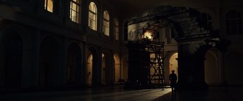 Movie still from “The Monuments Men” (2014), directed by George Clooney – A man standing on top of a wooden scaffolding; Extreme Wide shot, Low angle