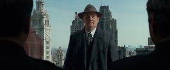 Movie still from “The Monuments Men” (2014), directed by George Clooney – An older man wearing a hat and a suit; Medium shot, Low angle