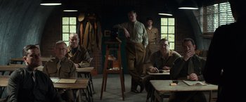Movie still from “The Monuments Men” (2014), directed by George Clooney – A group of men sitting around a room; Wide shot, Over the shoulder angle