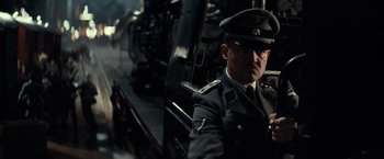 Movie still from “The Monuments Men” (2014), directed by George Clooney – A man in a military uniform next to a train; Medium shot, Low angle