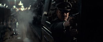 Movie still from “The Monuments Men” (2014), directed by George Clooney – A man in a military uniform is holding a gun; Close Up shot, Low angle