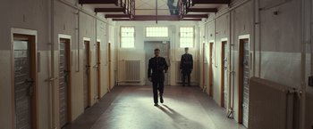 Movie still from “The Monuments Men” (2014), directed by George Clooney – A man in a uniform walking down a hall way; Wide shot, Low angle