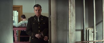 Movie still from “The Monuments Men” (2014), directed by George Clooney – A man in a military uniform standing in front of a door; Medium shot, Low angle