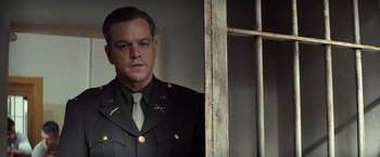 Movie still from “The Monuments Men” (2014), directed by George Clooney – A person wearing a suit and tie; Close Up shot, Low angle