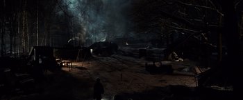 Movie still from “The Monuments Men” (2014), directed by George Clooney – A person standing in a field near a forest; Extreme Wide shot, High angle