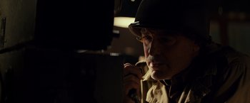 Movie still from “The Monuments Men” (2014), directed by George Clooney – An older man wearing a hat and glasses looking into a mirror; Close Up shot, Low angle