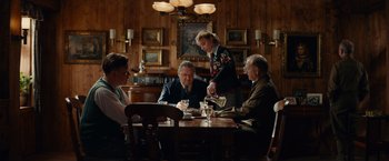 Movie still from “The Monuments Men” (2014), directed by George Clooney – A group of people sitting at a table in a restaurant; Wide shot, High angle
