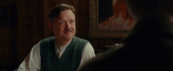 Movie still from “The Monuments Men” (2014), directed by George Clooney – A man sitting in front of a painting in a room; Close Up shot, Low angle