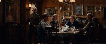 Movie still from “The Monuments Men” (2014), directed by George Clooney – A group of people sitting at a table in a room; Wide shot, Over the shoulder angle
